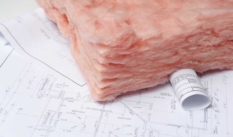 Fiberglass insulation batts on architectural blueprints for home construction in Portland, OR